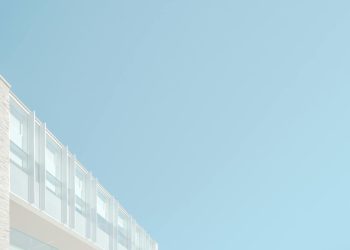 Low angle view of a modern building facade against a blue sky in London, Ontario.