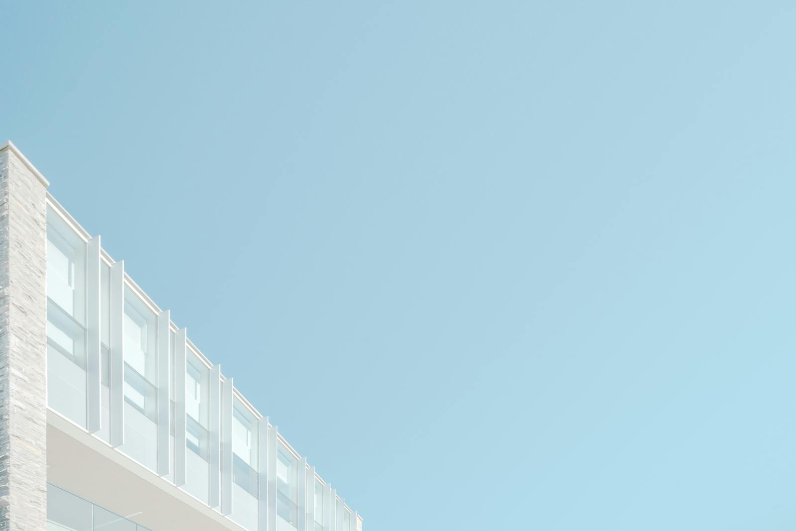 Low angle view of a modern building facade against a blue sky in London, Ontario.