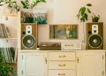 Retro home interior featuring vintage stereo, speakers, and houseplants for cozy atmosphere.