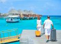A couple arriving at a luxurious Maldives resort dock with luggage, capturing a tropical vacation vibe.