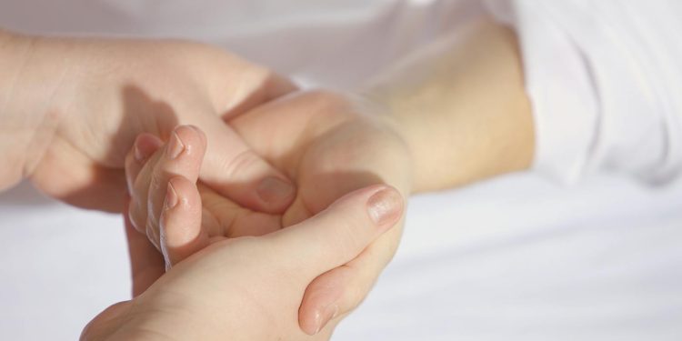 Relaxing hand massage therapy session close-up with gentle touch and care.