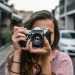 A woman captures a street scene with a classic camera in Surry Hills, Australia.