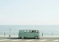A classic Volkswagen van driving on a seaside road in Fujisawa, Japan, capturing a nostalgic coastal vibe.