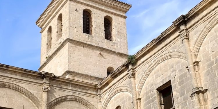 Stone monastery in Andalusian city with clear blue sky and classic architecture.