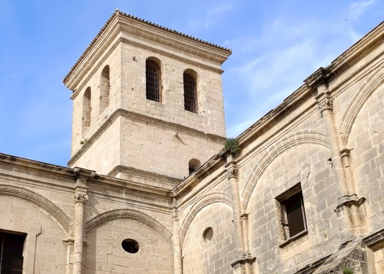 Stone monastery in Andalusian city with clear blue sky and classic architecture.