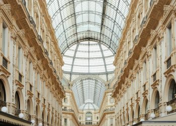 Beautiful view of Galleria Vittorio Emanuele II's interior glass roof and intricate facade in Milan, Italy.