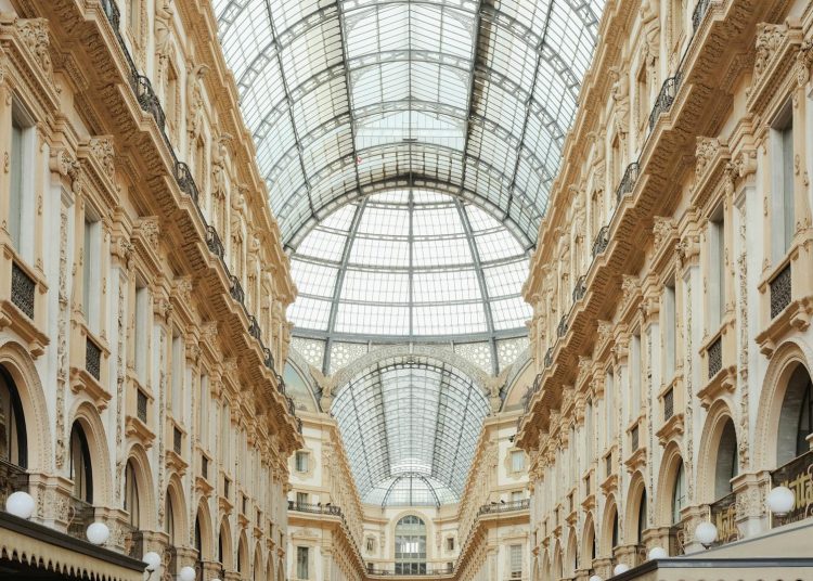 Beautiful view of Galleria Vittorio Emanuele II's interior glass roof and intricate facade in Milan, Italy.