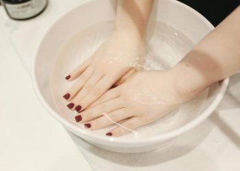 Luxurious hand spa treatment with elegant manicured nails submerged in a soothing soak.
