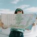 A woman holds a map while traveling through the scenic desert of California, USA.