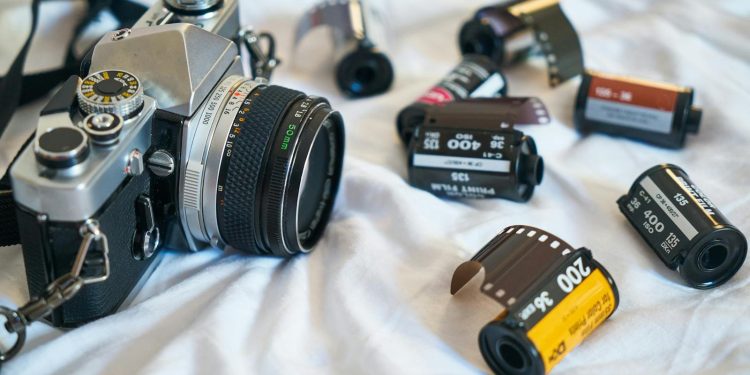 A classic film camera surrounded by various film rolls, evoking a retro photography vibe.