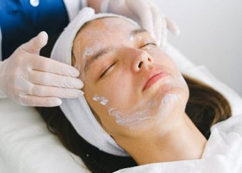 Woman receiving a facial treatment at a spa, promoting skin health and relaxation.