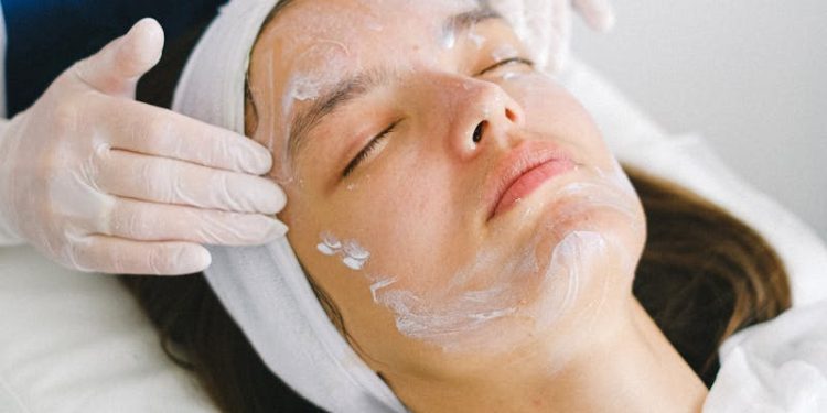Woman receiving a facial treatment at a spa, promoting skin health and relaxation.