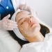 Woman receiving a facial treatment at a spa, promoting skin health and relaxation.