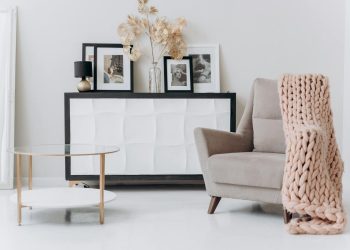 A cozy, contemporary interior setup with a beige chair, soft decor, and elegant furnishings.