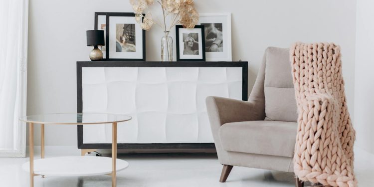 A cozy, contemporary interior setup with a beige chair, soft decor, and elegant furnishings.